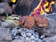 Steak cooking on campfire